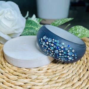 Sparkling acrylic bangle bracelet glistens with scattered colorful crystals
